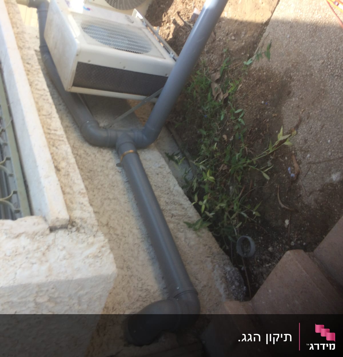 צינור אפור מחובר למזגן על גג